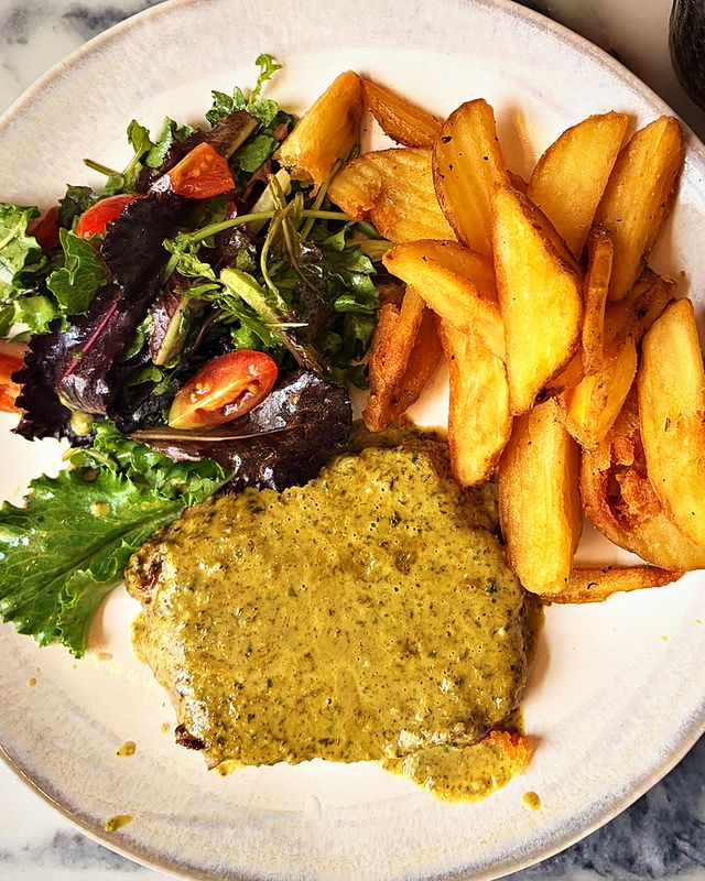 Bife com molho Café de Paris, batatas e salada